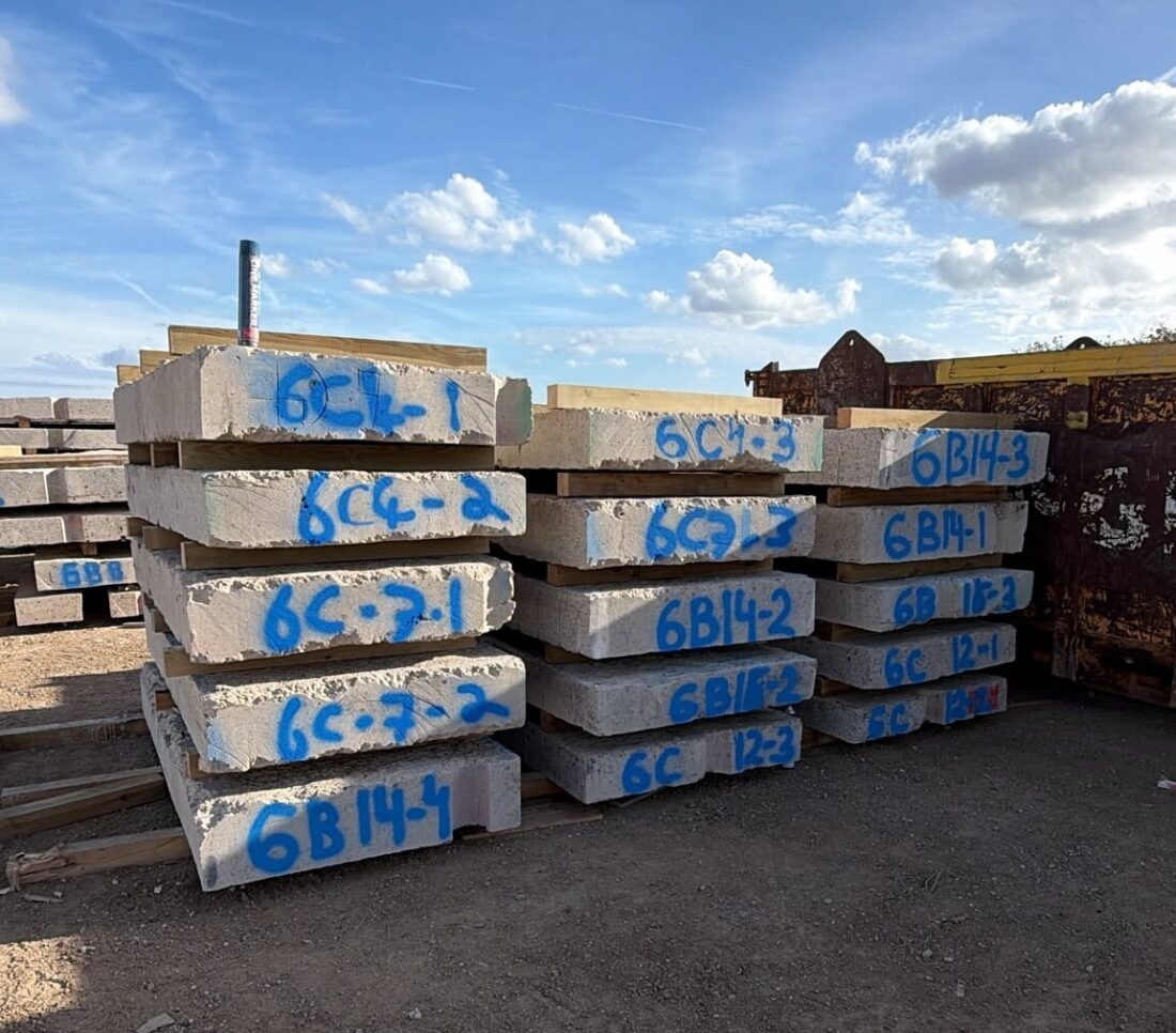 A photo of several concrete slabs cut down to size and stacked in piles, ready for coring and assembly